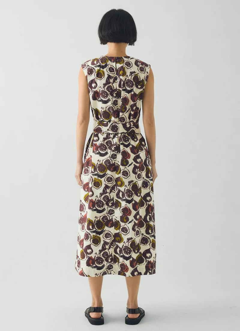 Woman wearing a sleeveless floral dress on a plain background viewed from behind