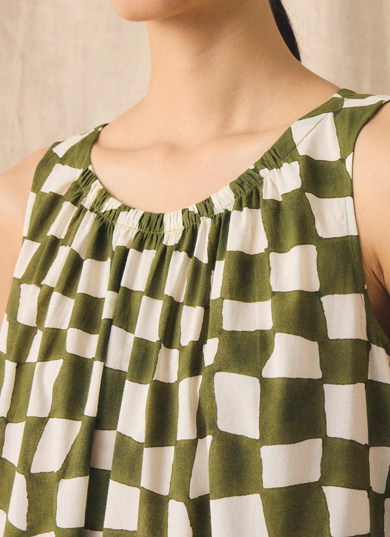 Detail of neckline of green and white dress on person