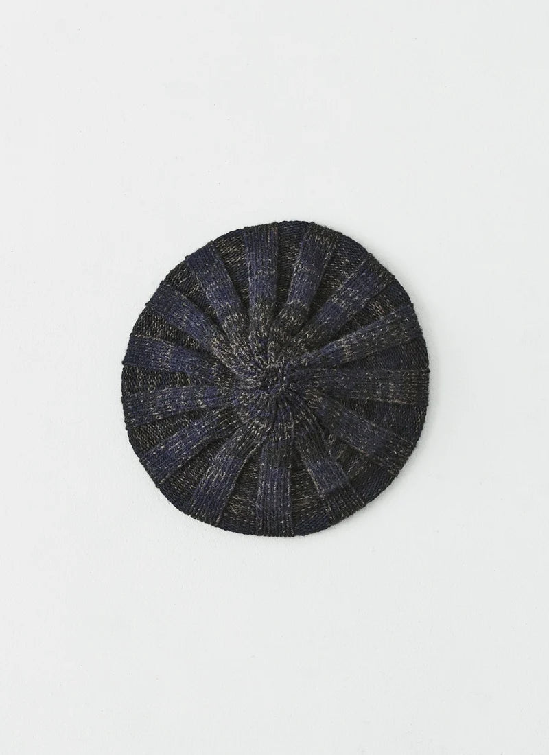 A round, dark navy blue knit beret hat with a textured, ribbed pattern, shown flat against a plain white background.