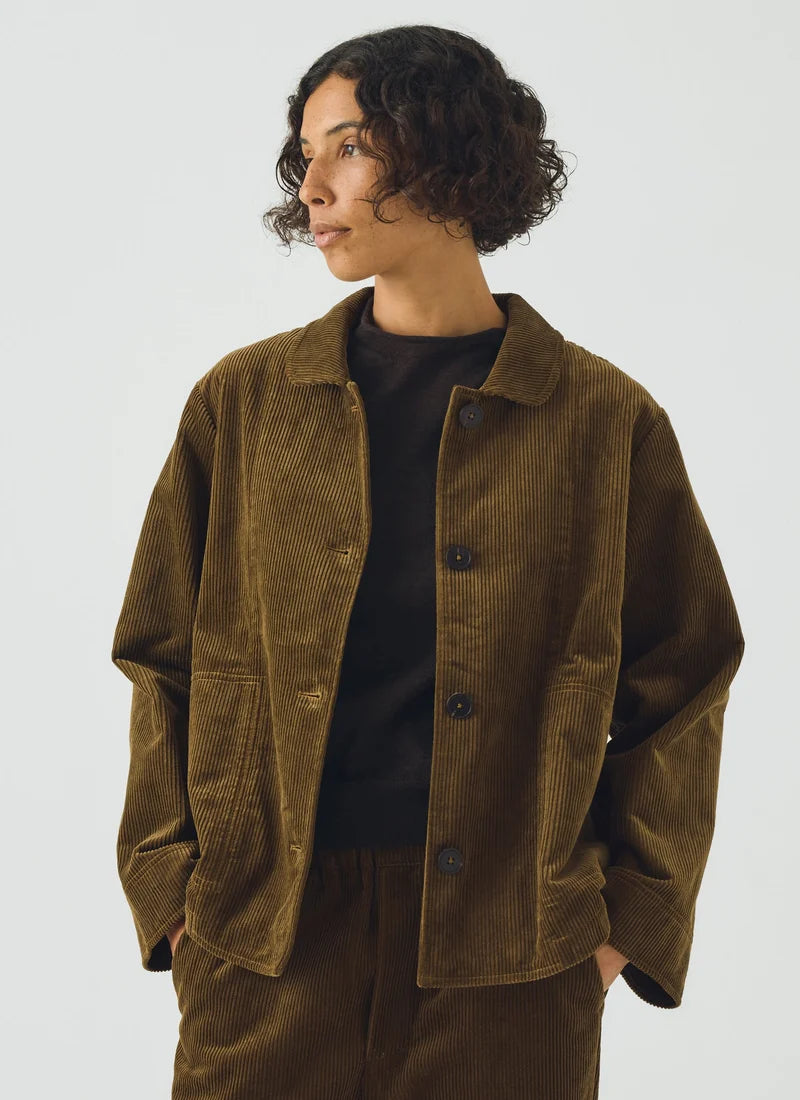 A woman wearing an olive green jacket over a black top.