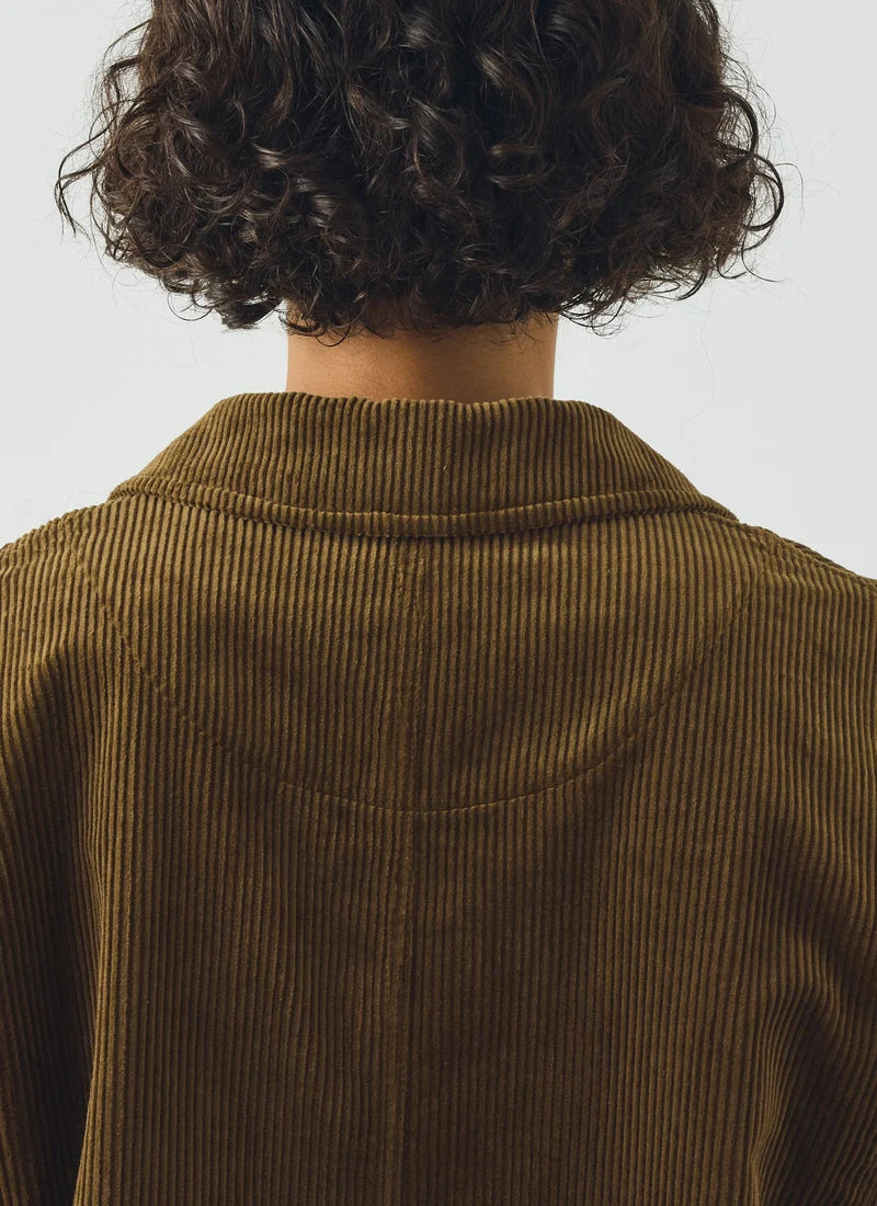 An olive green jacket shown on a model against a white background.