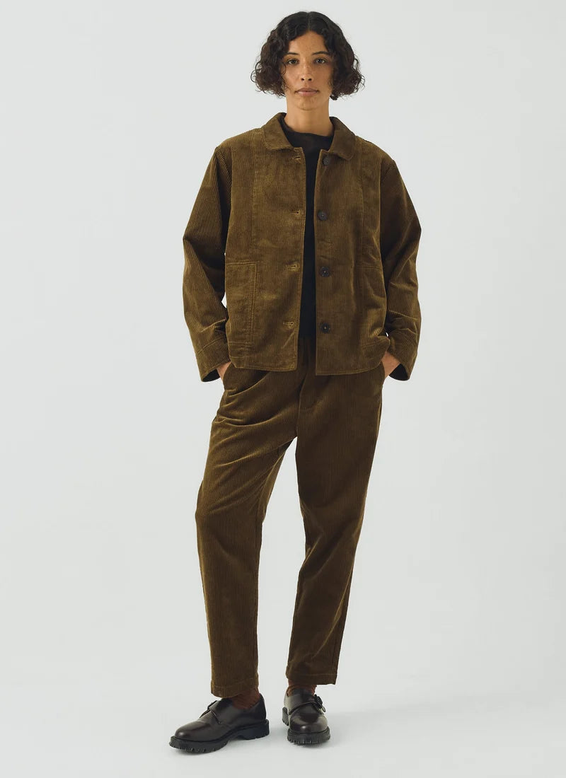 An olive green jacket with pockets shown on a model standing against a white background.