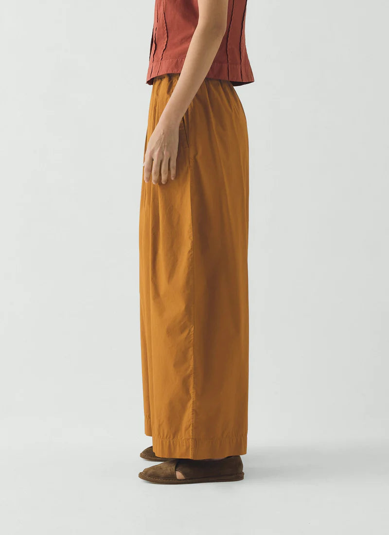 Brown pants worn by a person on a white background