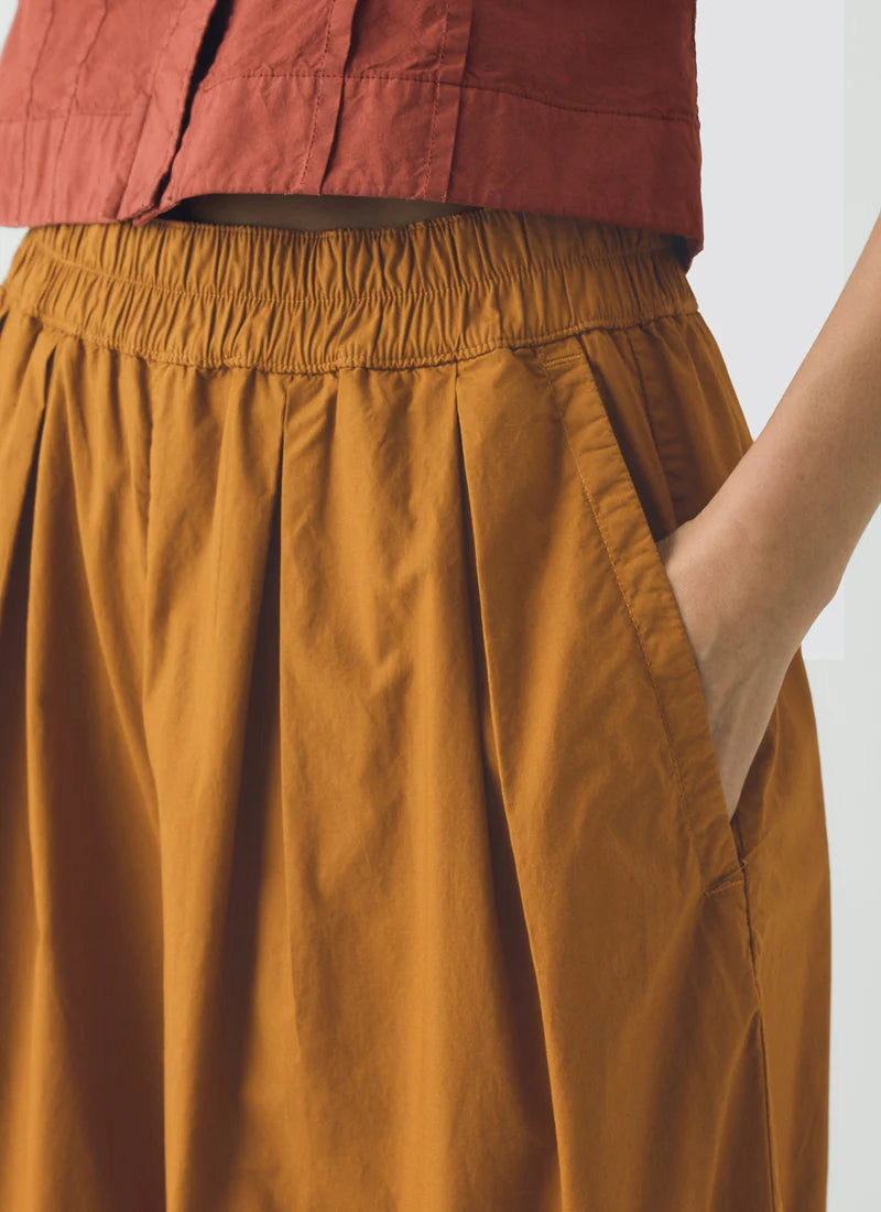 Brown pants worn by a person on a white background