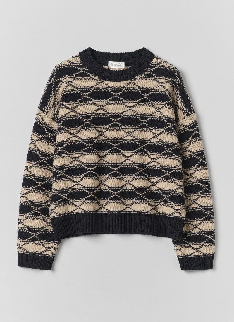 A striped blue and white jacquard sweater against a grey background.