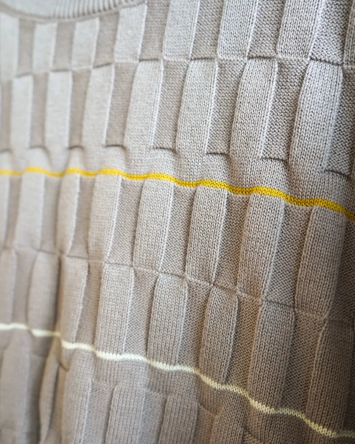 close up of pebble colored knitted sweater