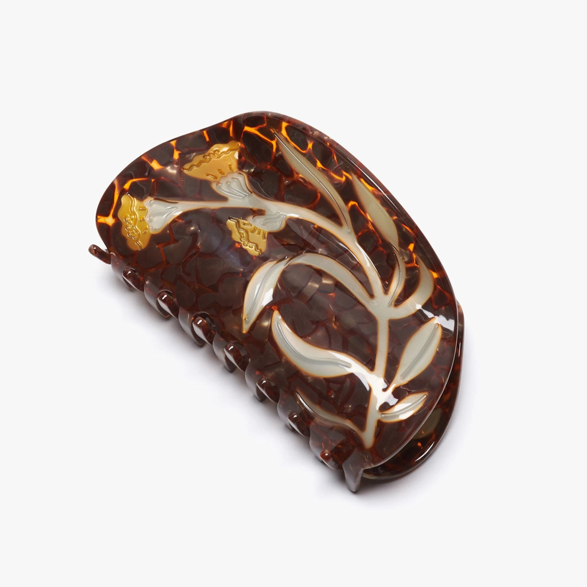 Decorative hair clip with tortoiseshell pattern and florals on a white background