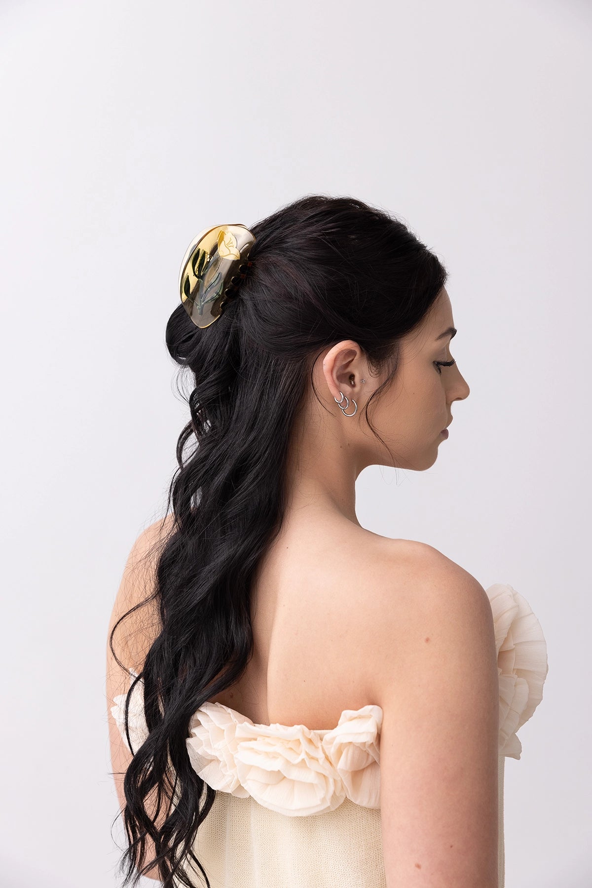 Model wearing a yellow hair claw clip with floral design.