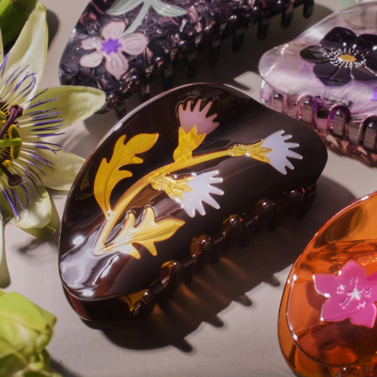 Decorative hair clips with floral designs on a light background