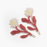 Decorative barrette with red leaves and white flowers on a white background