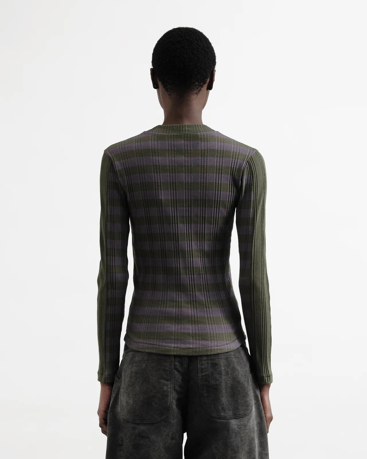 Person wearing a green and purple checkered sweater on a white background