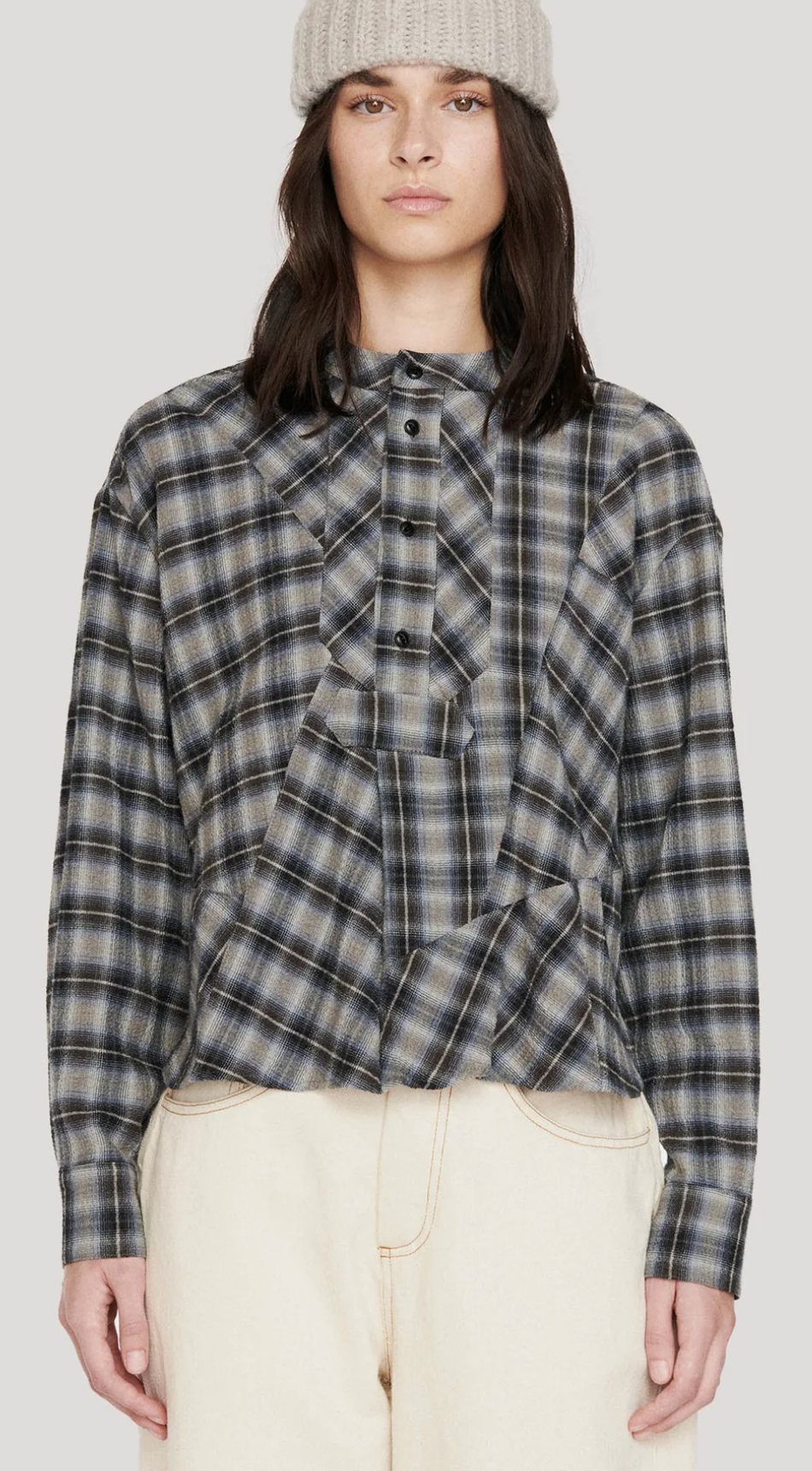 Front view of black blue check 4 button collarless long sleeve shirt. Worn with ecru jeans