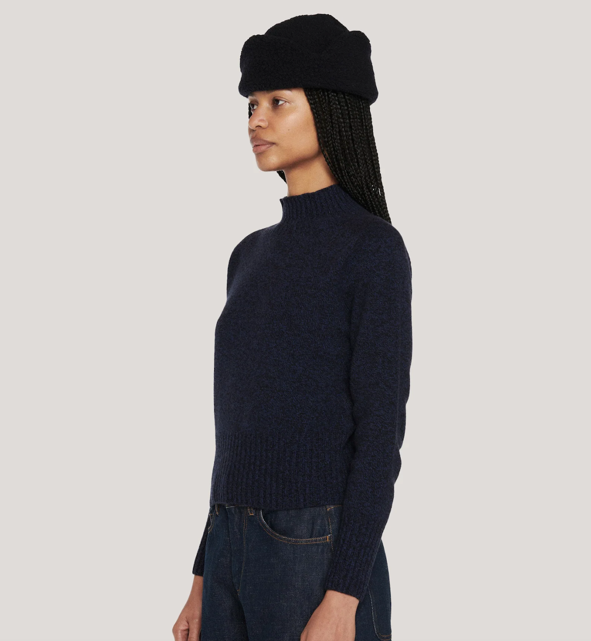 Side view of woman wearing mottled blue high neck sweater