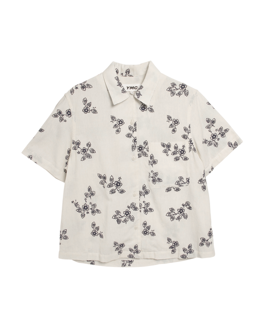 Front view of woman's white short sleeve shirt with navy blue embroidered flower motif