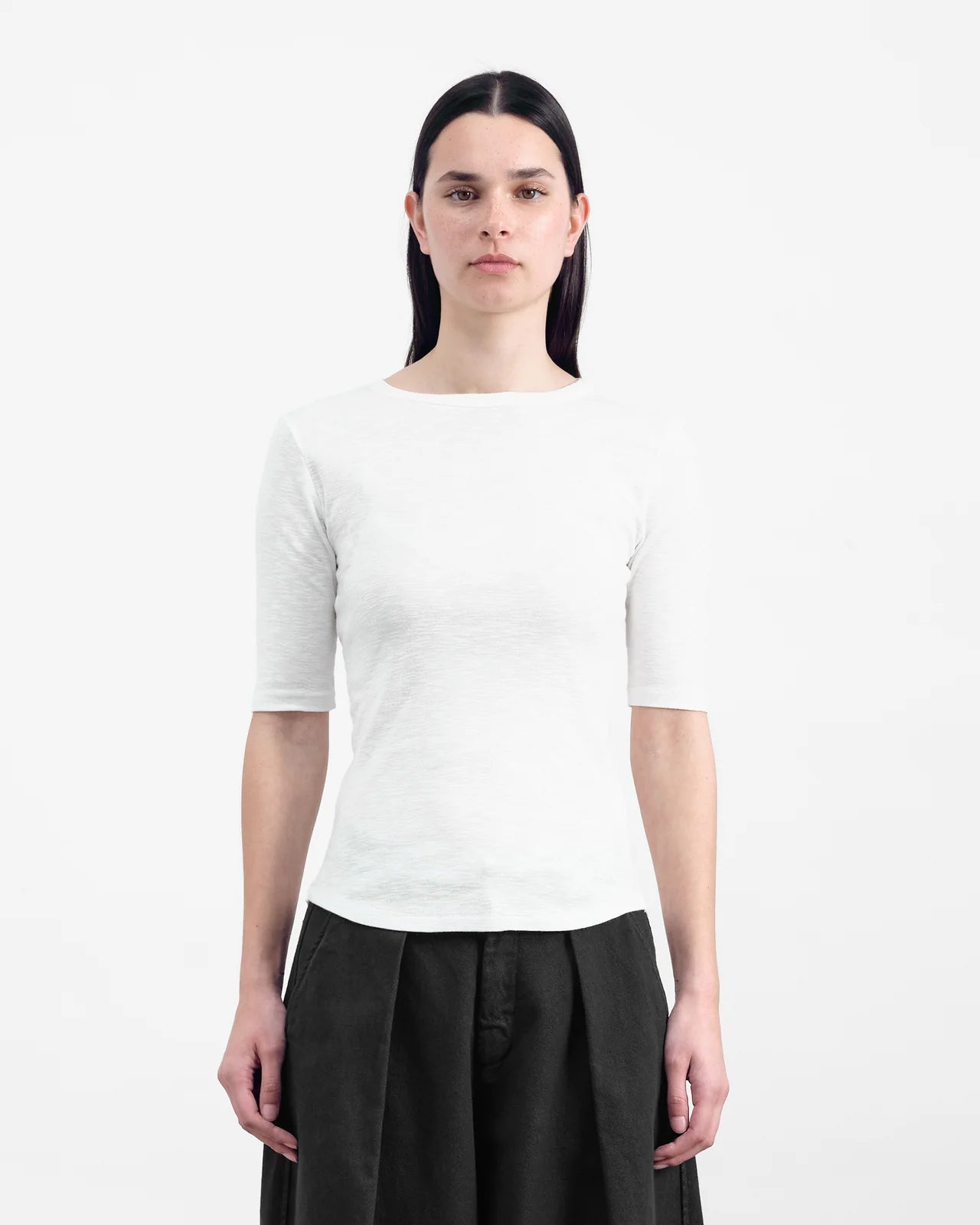 Person wearing a white short-sleeve shirt and black pants on a white background