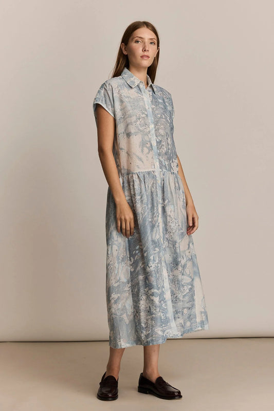Woman wearing a print dress against a plain background