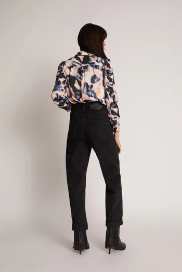 Back view showing print blouse tucked into black jeans