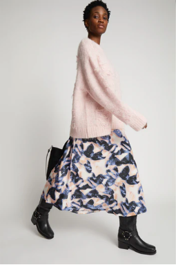 print blue/pink skirt worn with black boots and an oversized pink cardigan