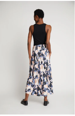 Back view of model in long print skirt and black tank top