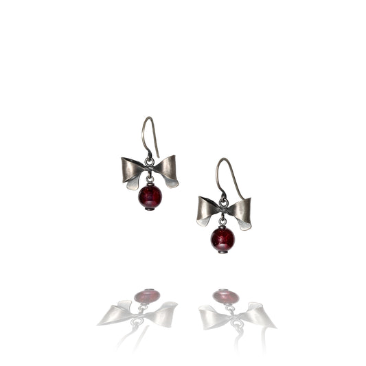 Oxidized Sterling silver bow earrings with garnet beads on a white background