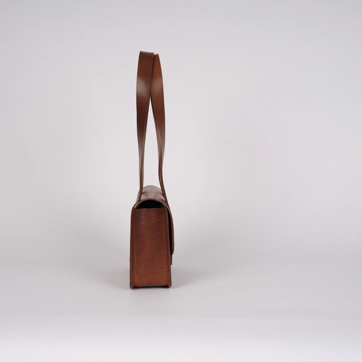 Brown leather bag with a handle on a white background