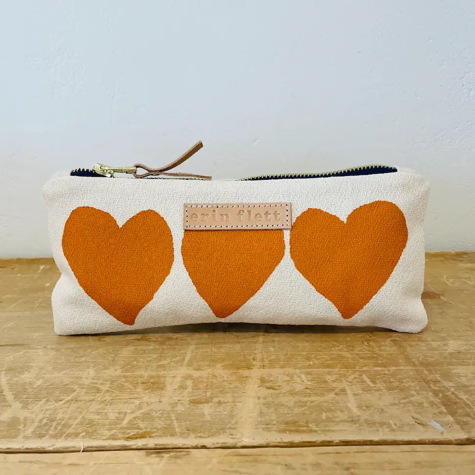 Pouch with orange hearts on a wooden surface