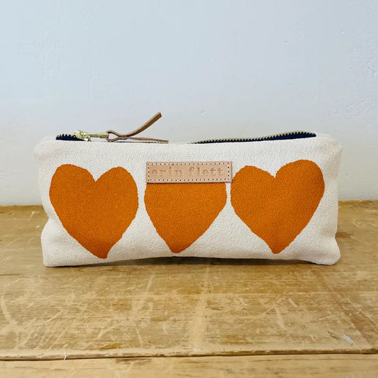Pouch with orange hearts on a wooden surface