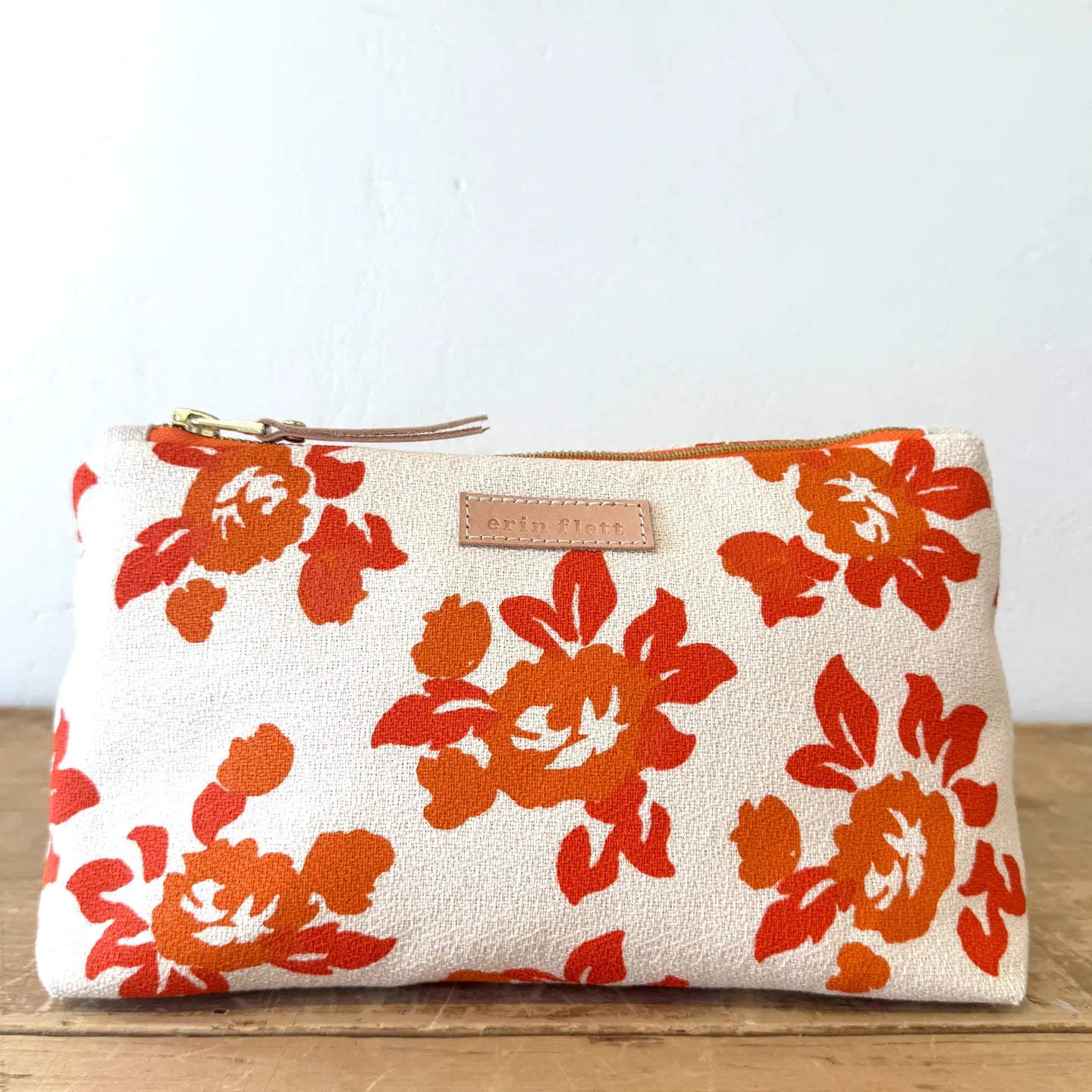 Floral-patterned pouch with orange flowers on a white background