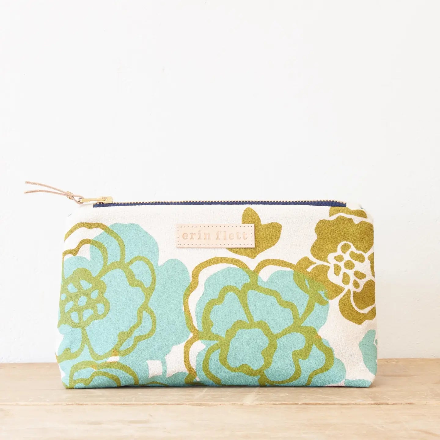 Floral patterned pouch with a visible brand label on a light background
