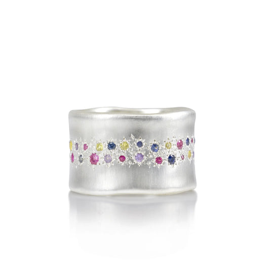 Silver ring with colorful gemstones on a white background