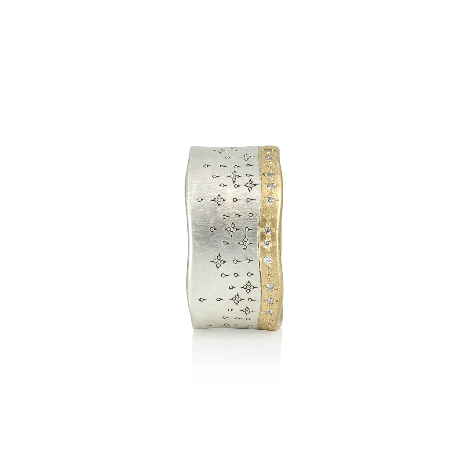 Gold and silver ring with star designs on a white background