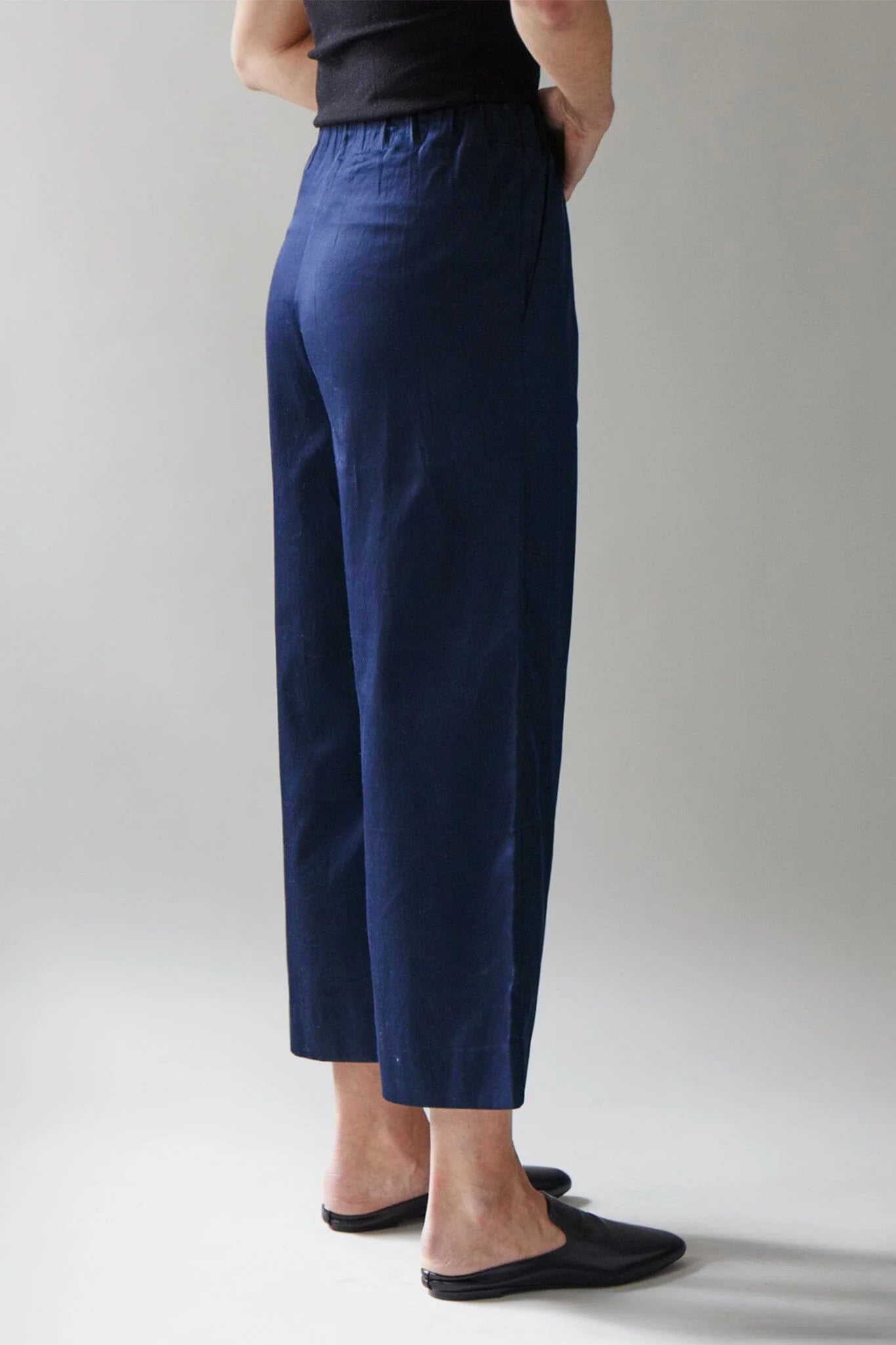 Person wearing navy blue pants on a plain background
