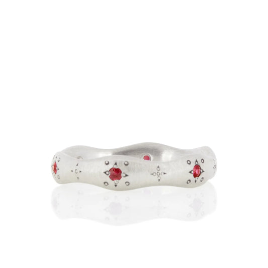 Silver ring with red gemstones on a white background