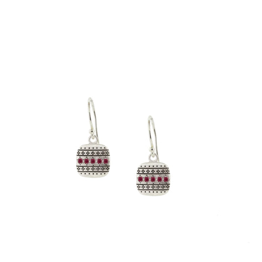 Pair of silver earrings with red gemstones on a white background