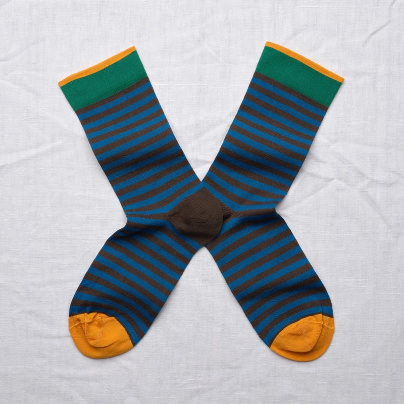 Pair of striped socks with green, blue, and orange colors on a light gray background